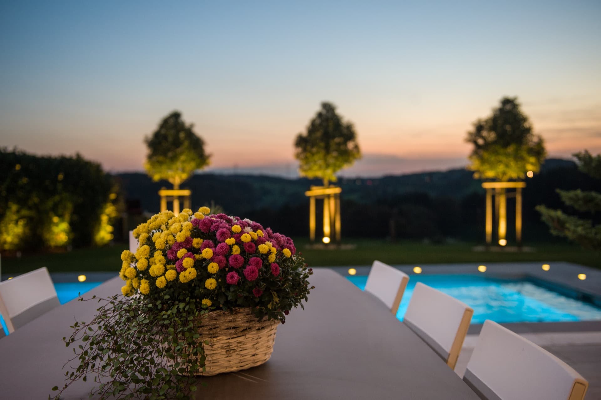 Abendliche Poollandschaft mit Blüten und Licht