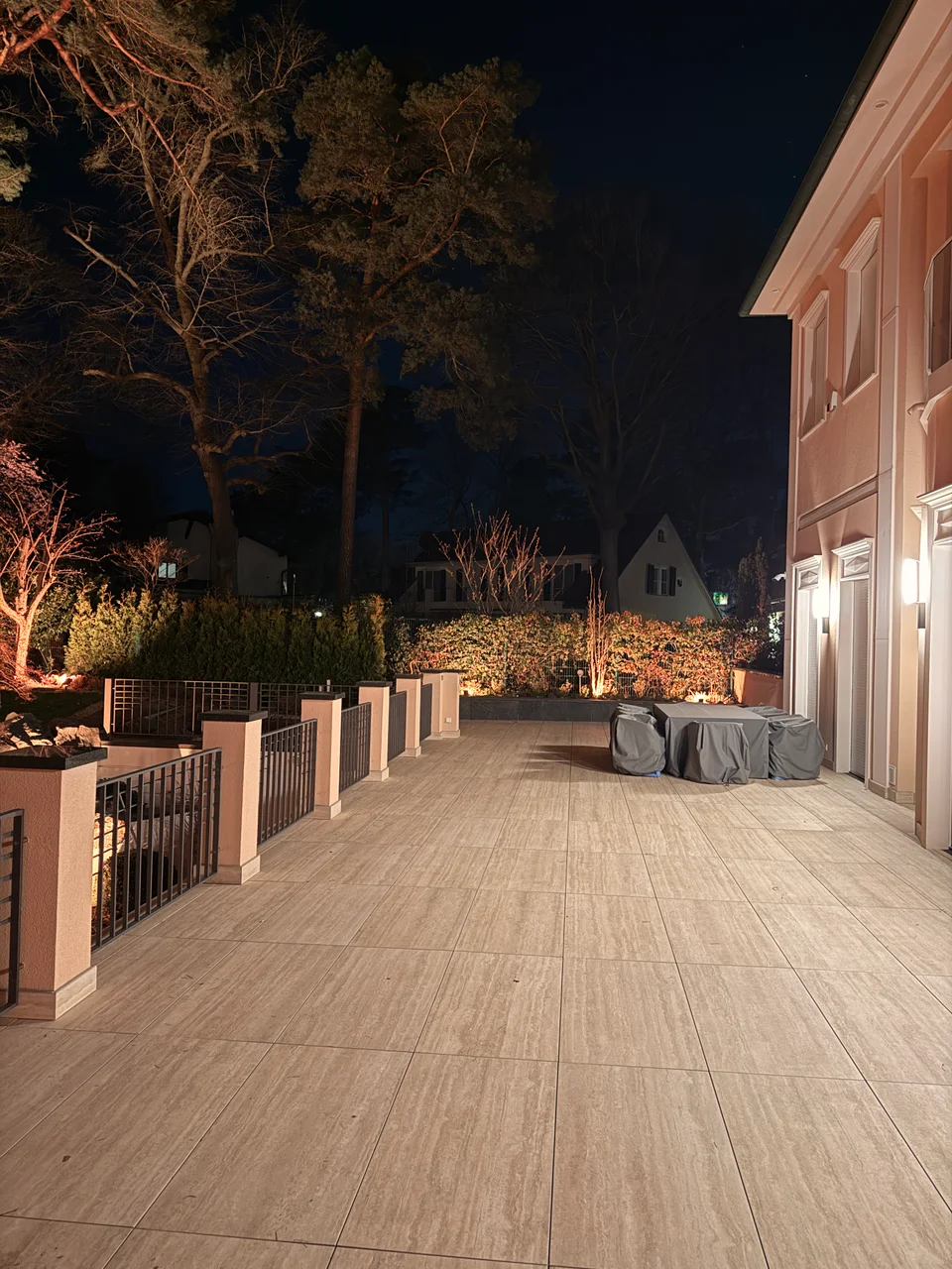 Blick von der Terrasse in den beleuchteten Garten bei Nacht