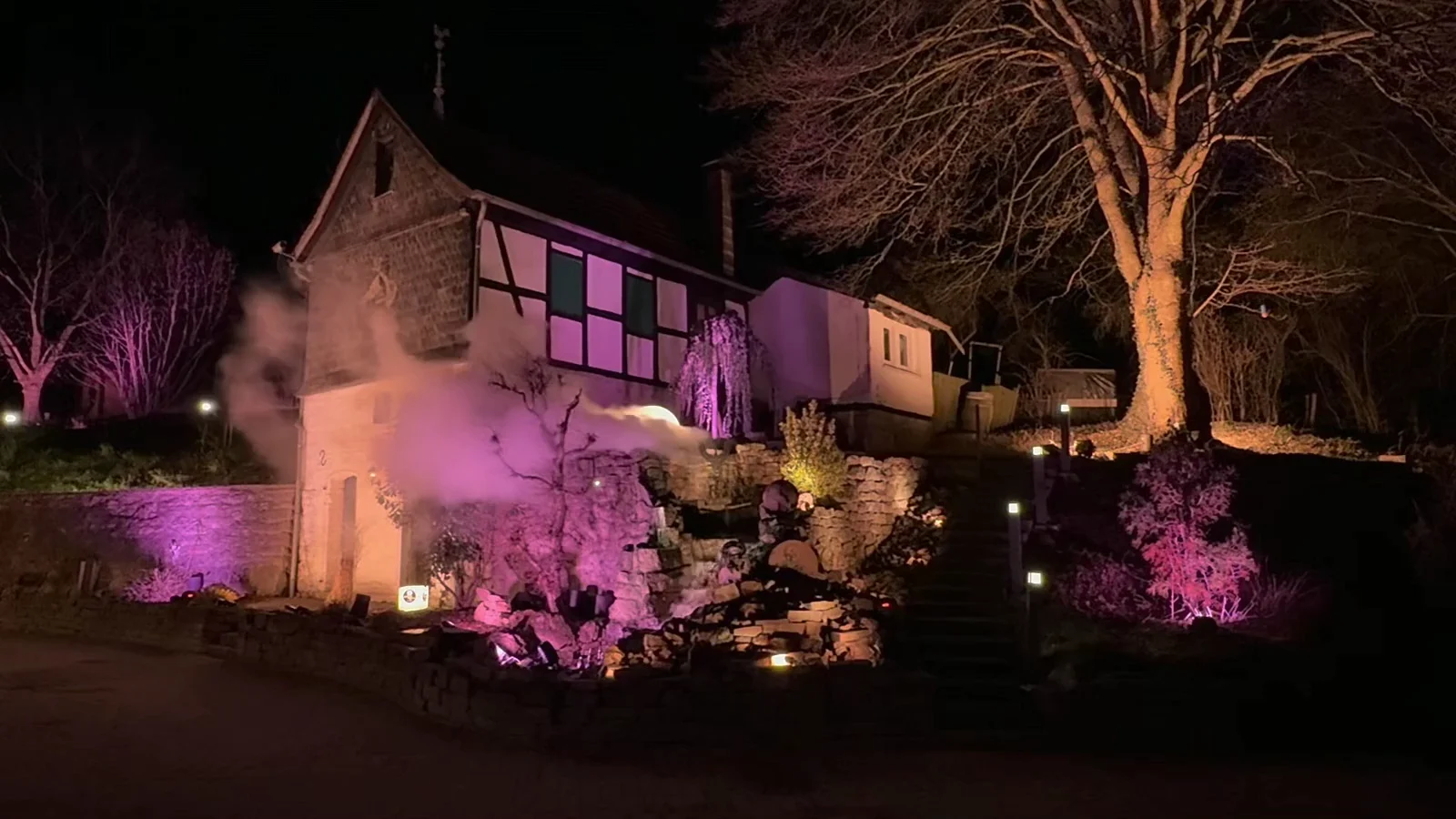Beleuchtete Bäume und Naturstein auf Gut Asselborn bei Nacht